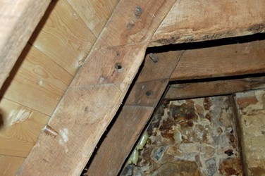 <p>Detail van de verbinding van de haanhouten van enkele hergebruikte 14e-eeuwse daksporen van het rechter huis. Op de foto is goed te zien dat de haanhouten oorspronkelijk een stukje lager verbonden waren met de sporen. </p>
